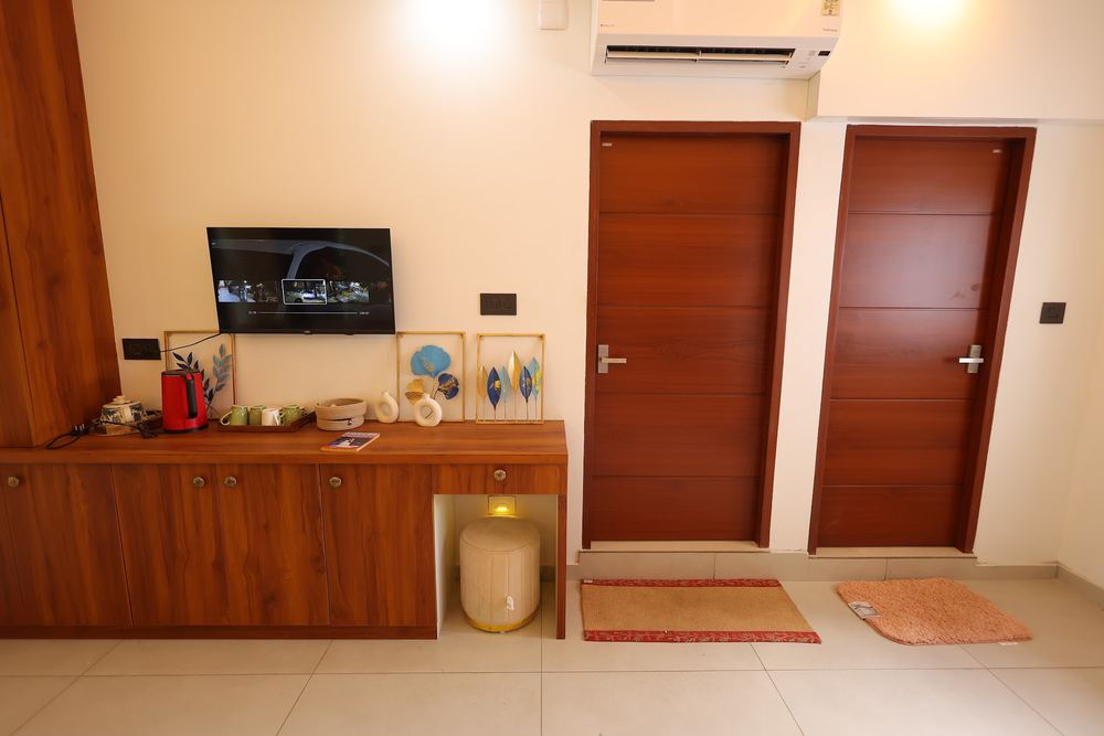 Tea station, TV and two wooden doors by the room entrance