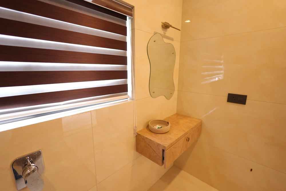 A wall-mounted vanity and round mirror in the bathroom