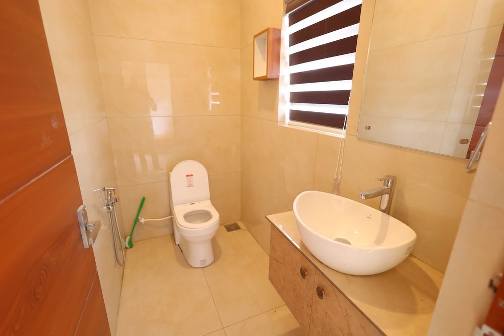 Vessel sink, commode and mirrored cabinet in a marble bathroom