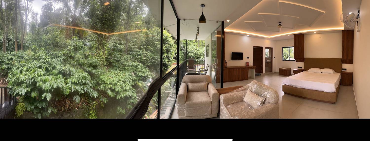 Panorama: coffee bushes pressing against the glass wall, the room and balcony beyond